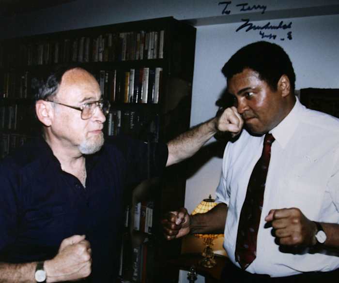 Sports writer Jerry Izenburg lands a friendly punch on Muhammad Ali.
